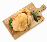 A raw corn-fed chicken on a chopping board