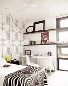 Black & white bedroom with bed and wall-mounted shelving above desk
