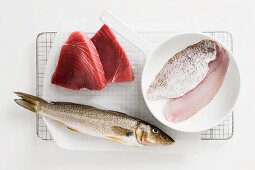 Various types of fish for frying, some in a pan