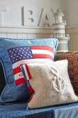 Kissen mit amerikanischer Flagge, auf teilweise sichtbarem Sofa, im Hintergrund Miniatur Leuchtturm
