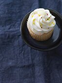 Vanille-Cupcake verziert mit bunten Zuckerstreuseln