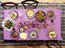 A bird's eye view of a springtime table laid with sweet and savoury dishes