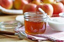 A jar of honey, yogurt and fresh apples