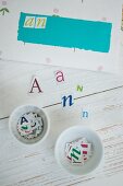 Hand-crafting envelopes - paper letters on wooden surface and sorted in white china dishes