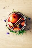 Marinated plums with anise, cinnamon, vanilla and rum in a preserving jar (seen from above)