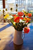 Bouquet of colourful poppies on table in sunshine