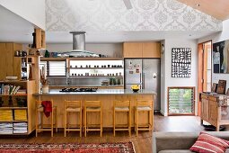 Wooden cupboards, counter and bar stools in open-plan kitchen in traditional interior
