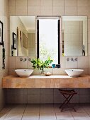 Modern floating washstand with two countertop basins below mirrors flanking window