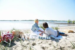 Couple and dog enjoying beach picnic