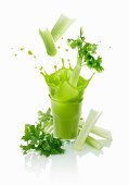Celery sticks falling into a vegetable drink