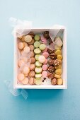 Verschiedene bunte Macarons in Geschenkkiste (Aufsicht)