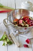Sliced rhubarb in a silver colander on a wooden table