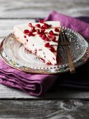 A slice of cheesecake with pomegranate seeds