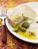 Rosmarinöl mit Brot und grünen Oliven