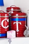 Red storage containers decorated with metal letters