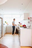 Man, child and dog in white kitchen