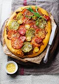A pizza with various different tomatoes and rocket