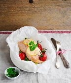 Salmon fillet in parchment paper with lemon and cherry tomatoes