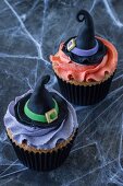 Two Halloween cupcakes decorated with witches hats