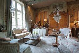 A sales exhibition of antique furniture and chandeliers with price labels in the parlour of an old French country house