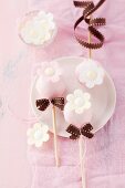 Birthday cake pops with sugared flowers and bows