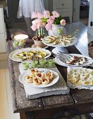A festive buffet with various canapés on a rustic wooden table