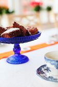 Pieces of chocolate cake on blue glass cake stand