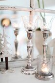 Elegant, silver candlesticks with glass shades and matching tealight holder
