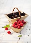 Raspberries and blackberries in wooden baskets