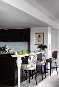 Bar stool with patterned fabric covers at marble counter in open-plan, modern kitchen area