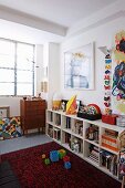 Modern art above open-fronted shelves in child's bedroom