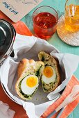 A bread roll filled with egg and spinach in a bread basket