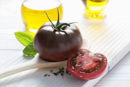 A black tomato on a wooden spoon
