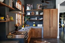 Gemauerte Küchenzeile und Massivholz Schrankfronten in offener Küche mit schwarz getönter Wand
