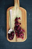 Cranberry jam on a spoon and on a chopping board