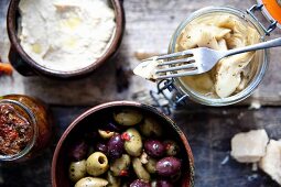 Italienische Antipasti: Eingelegte Oliven, Artischockenherzen, Bohnendip und getrocknete Tomaten