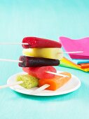 Colourful homemade fruit ice lollies stacked on a plate