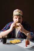 Typisch amerikanischer Mann mit Burger, Pommes und Cola