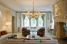 Sofa combination in grand, British manor house with lit chandelier and table lamps