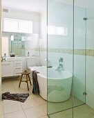 View through open door into designer bathroom - glazed shower area in front of bathtub on sand-coloured floor tiles