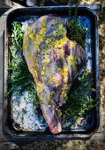 A leg of lamb ready to roast in a roasting tin