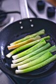 Leek being fried in a pan