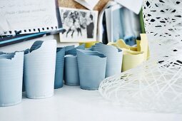 Experimentation with colour: 'Daily Soap' vases with matt surfaces made by artist from old plastic beakers next to mesh light sculpture