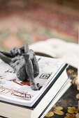 Reclined nude figurine made from dark metal on top of book