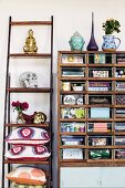 Vintage shelving unit next to Buddha figurine and skull ornament on ladder-style shelving