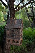 Vintage Vogelhäuschen mit Ketten an Baum gehängt in sommerlicher grüner Natur
