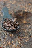 Pu-Ehr-Tee als Teefladen & Teeblätter auf Löffel