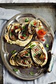 Naan bread with grilled aubergines, hummus and a chilli dressing