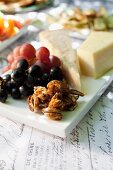 A cheese platter with caramelised pecan nuts and grapes