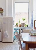 Vintage dining set opposite fifties fridge in retro kitchen in period building